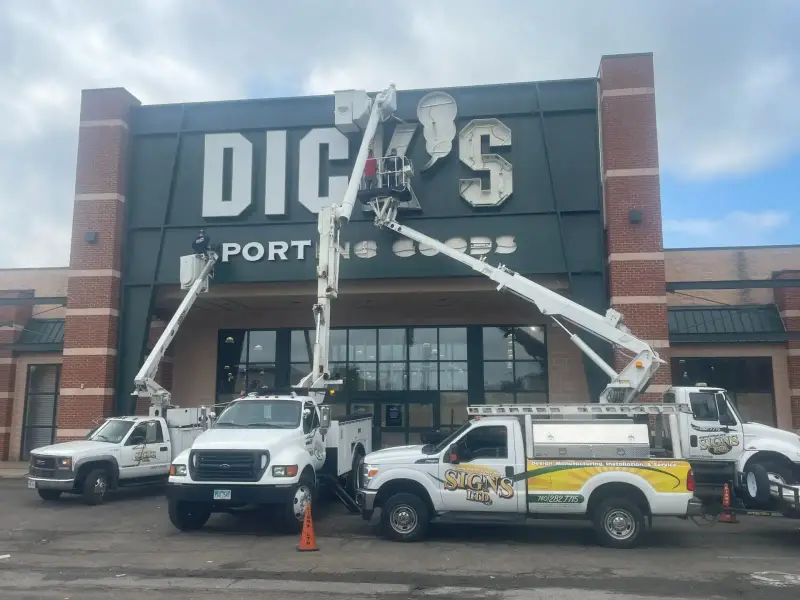 Signs Limited installation crew and bucket trucks at a Dick's Sporting Goods storefront