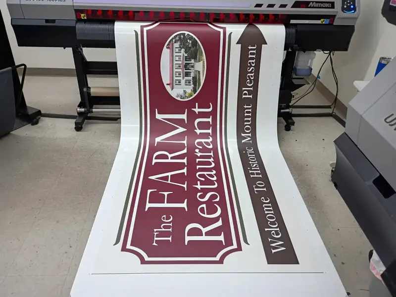 Printed restaurant banner coming off a wide-format printer