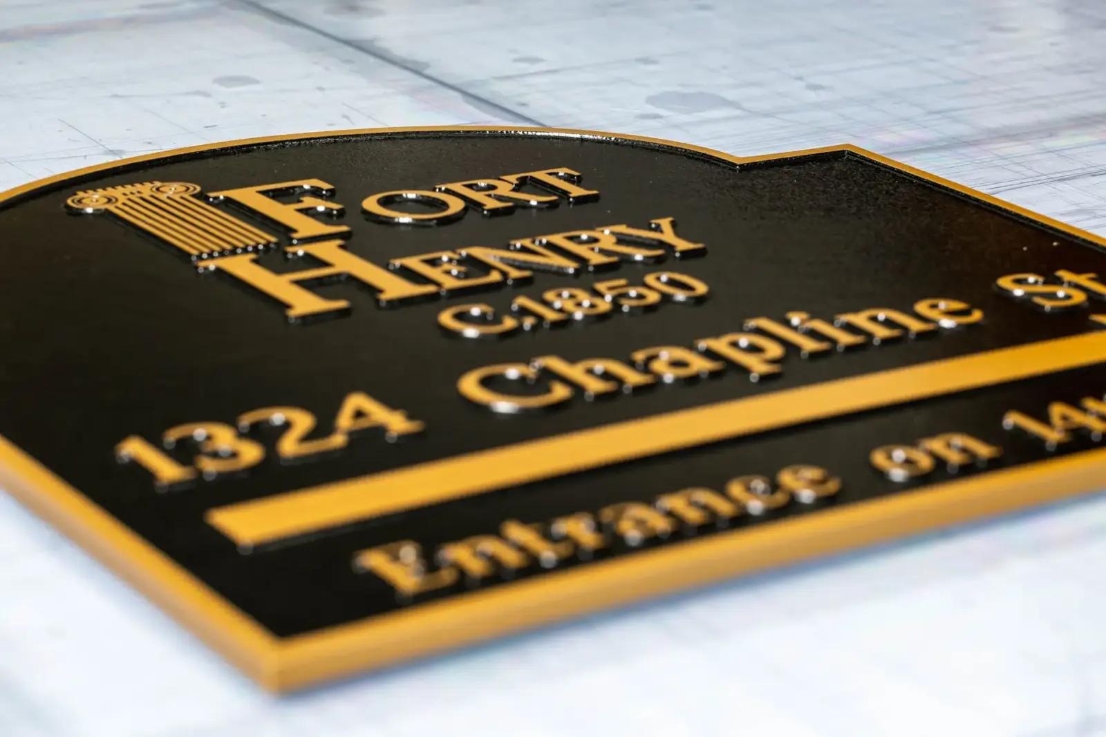 Engraved black and gold plaque reading Fort Henry, 1324 Chapline St