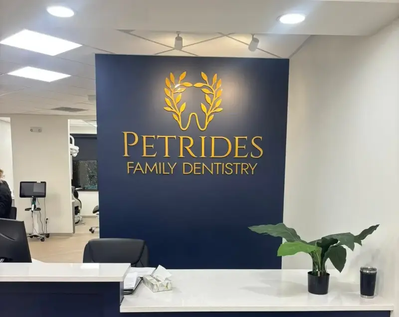 Gold dimensional lobby logo at Petrides Family Dentistry