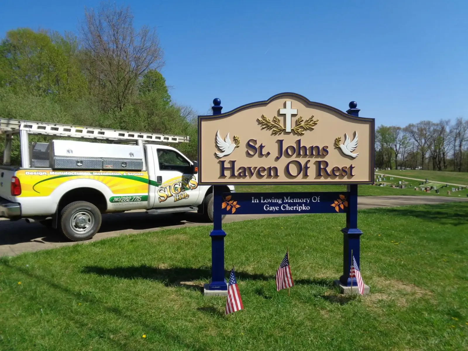 Post and panel memorial sign at St. Johns Haven of Rest with a Signs Limited service truck